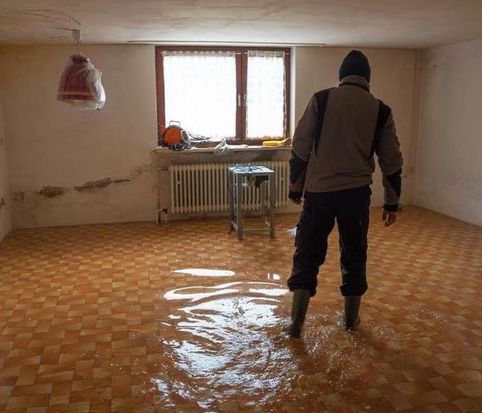 A man walks through a flooded basement